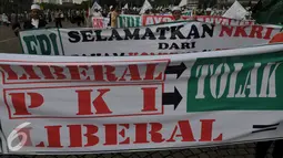Sejumlah spanduk dibawa saat aksi menolak PKI dan Liberalisme di kawasan Monas, Jakarta, Jumat (3/6). Mereka menuntut Presiden Jokowi untuk menolak keberadaan PKI dan Liberalisme. (Liputan6.com/Johan Tallo)
