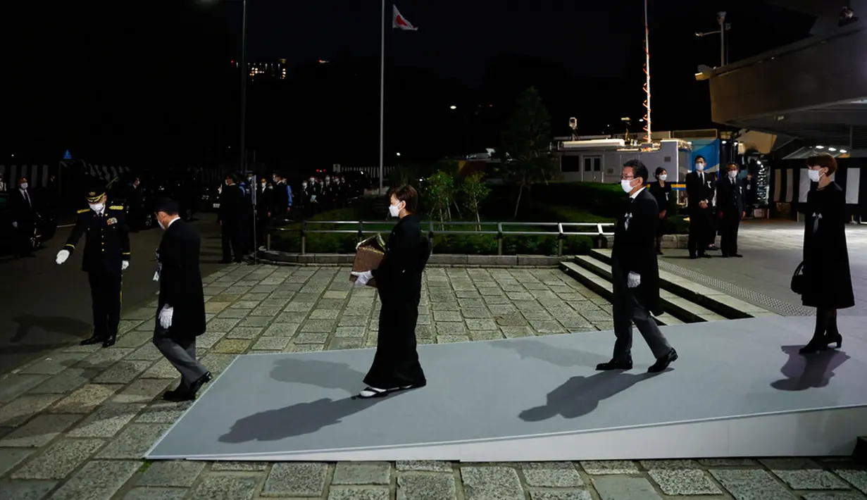 Akie Abe (tengah), istri mantan Perdana Menteri Jepang Shinzo Abe membawa guci suaminya saat meninggalkan pemakaman kenegaraan di Nippon Budokan, Tokyo, Jepang, 27 September 2022. Biaya pemakaman kenegaraan Shinzo Abe disebut lebih besar dari pemakaman kenegaraan Ratu Elizabeth II. (Kiyoshi Ota/Pool Photo via AP)