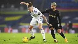 Gelandang Leeds United, Kalvin Phillips (kiri) membawa bola dari kawalan penyerang West Ham, Said Banrahma pada pertandingan lanjutan Liga Inggris di stadion Elland Road di Leeds, Inggris, Sabtu (12/12/2020). West Ham menang tipis atas Leeds United 2-1. (Gareth Copley, Pool via AP)