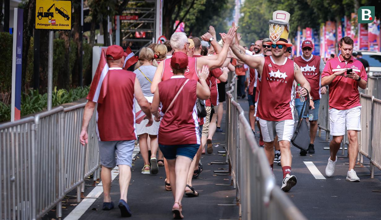 <p>Pendukung Latvia mengenakan topi berbentuk ring basket saat berjalan memasuki venue menjelang laga perdana Grup H Piala Dunia FIBA 2023 antara Timnas Basket Latvia melawan Timnas Basket Lebanon di Indonesia Arena, Senayan, Jakarta, Jumat (25/08/2023). Lebanon menang dengan skor 109-70. (Bola.com/Bagaskara Lazuardi)</p>