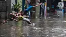 Sejumlah anak bermain saat banjir melanda kawasan Kemang Utara, Jakarta, Kamis (4/1/2024).(Liputan6.com/Herman Zakharia)