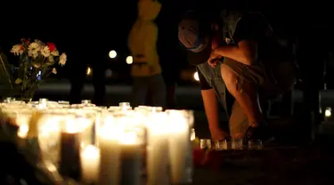 Aidan Solis (11) berlutut saat mengikuti aksi  menyalakan lilin dan berdoa bersama di San Bernardino, California, Jumat (4/12). Aksi tersebut untuk korban penembakan brutal di pusat lembaga pelayanan sosial yang menewaskan 14 orang (REUTERS/Mario Anzuoni)