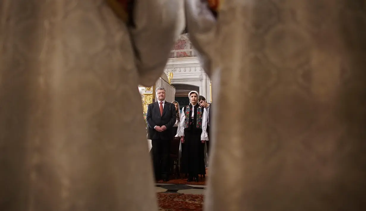 Presiden Ukraina Petro Poroshenko dan istrinya Maryna Poroshenko menghadiri Paskah Ortodoks di Biara Volodymyrskiy di Kiev, Ukraina (8/4). (AP Photo / Evgeniy Maloletka)