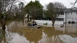 Warga mendayung melalui jalan banjir di Windsor di pinggiran Sydney, Australia, Selasa (5/6/2022). Ratusan rumah terendam di dalam dan sekitar kota terbesar Australia itu dalam keadaan darurat banjir yang berdampak pada 50.000 orang, kata para pejabat. (AP Photo/Mark Baker)