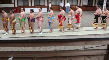 Sejumlah pegulat sumo berbaris untuk berdoa di Kuil Yasukuni di Tokyo, Jepang, Senin (17/4). (AP Photo / Shizuo Kambayashi)