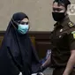 Terdakwa suap dan TPPU terkait pengurusan fatwa Mahkamah Agung untuk Djoko S Tjandra, Pinangki Sirna Malasari (tengah) saat jeda sidang pembacaan putusan di Pengadilan Tipikor Jakarta, Senin (8/2/2021). Sebelumnya, Pinangki dituntut hukuman empat tahun penjara. (Liputan6.com/Helmi Fithriansyah)