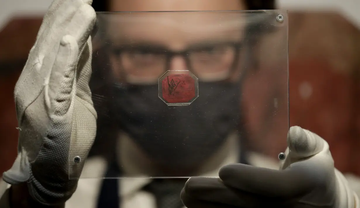 Sebuah prangko British Guiana One-Cent Magenta difoto di rumah lelang Sotheby, London, Rabu (28/4/2021). Prangko paling langka di dunia itu diperkirakan terjual US $ 10 juta hingga $ 15 juta (sekitar Rp 144,7 M - Rp 216,8 M) dalam penjualan di Sotheby's New York pada 8 Juni. (AP Photo/Matt Dunham)