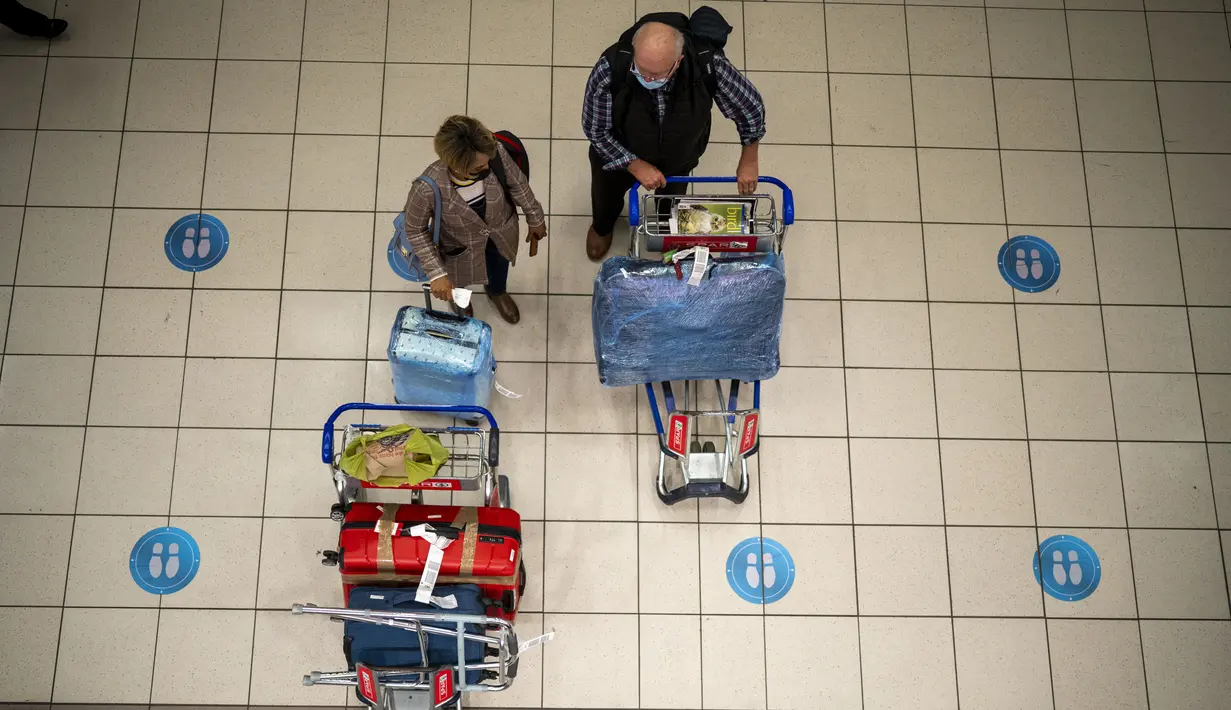 Orang-orang menunggu di bandara OR Tambo di Johannesburg, Jumat (26/11/2021). Sejumlah negara bergerak untuk menghentikan perjalanan udara dari Afrika Selatan sebagai reaksi terhadap berita varian baru COVID-19 yang berpotensi lebih menular yang telah terdeteksi di Afrika Selatan. (AP/Jerome Delay)