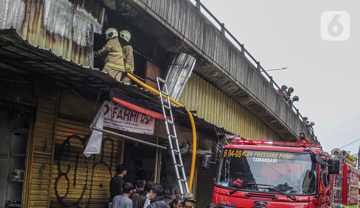 Petugas pemadam kebakaran saat melakukan proses pendinginan dari kebakaran di Pasar Pagi Asemka, Jakarta, Jumat (18/11/2022). Menurut Kepala Sektor Tambora Sudin Gulkarmat Jakarta Barat, Joko Susilo, api menghanguskan sekitar 20 lapak pedagang. (Liputan6.com/Faizal Fanani)