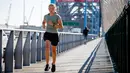 Seorang pelari berolahraga di Brisbane Story Bridge yang hampir sepi di Brisbane, Australia (30/6/2021).  Lockdown di Brisbane ini mulai berlaku pada Selasa malam. (AFP/Patrick Hamilton)