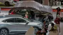 Seorang model berdiri di samping mobil yang dipamerkan saat pembukaan Indonesia International Motor Show (IIMS 2019) di JIExpo Kemayoran, Jakarta, Kamis (25/4). Pameran industri otomotif tersebut berlangsung 25 April - 5 Mei 2019. (Liputan6.com/Faizal Fanani)