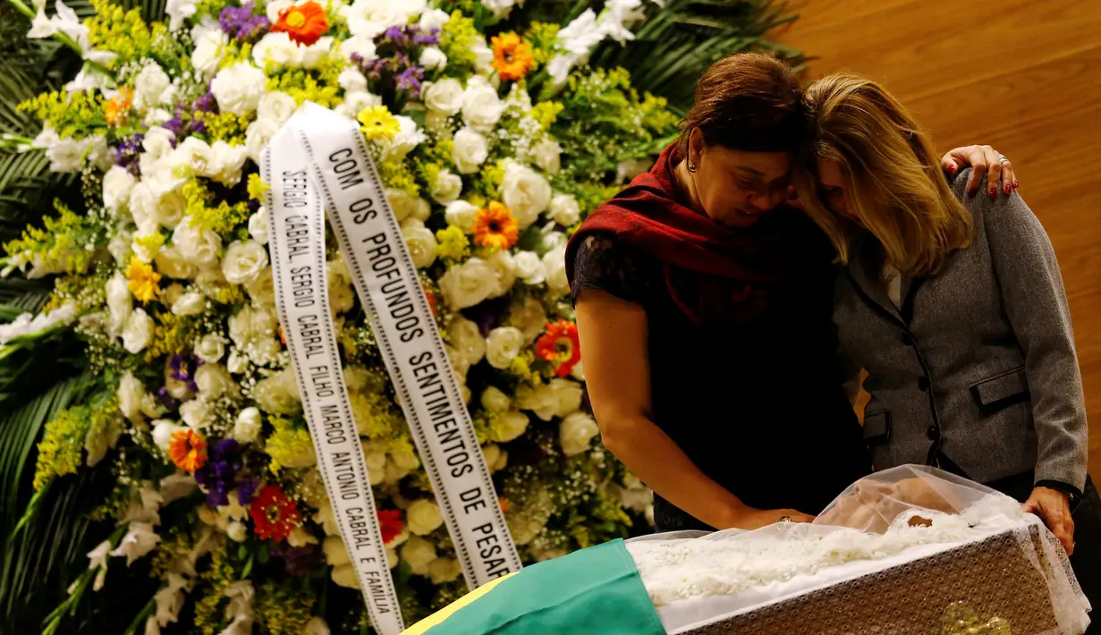 Istri mendiang Carlos Alberto, Graca Garbaccio (kanan) saat melihat jenazah suaminya di Konfederasi Sepakbola Brasil (CBF) di Rio de Janeiro, Brasil (25/10). Mantan kapten tim sepak bola Brasil ini meninggal di usia 72 tahun. (Reuters/ Ricardo Moraes)