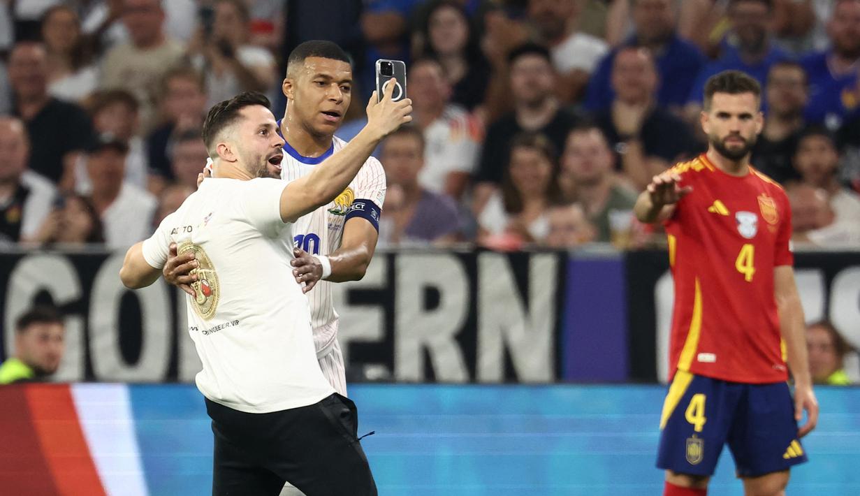 Pria itu berlari melewati petugas keamanan dan masuk ke lapangan saat waktu tersisa sekitar 58 menit di babak kedua. (FRANCK FIFE / AFP)