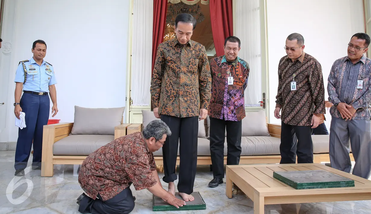Presiden Joko Widodo berdiri untuk dicetak kakinya di Istana Merdeka, Jakarta, Selasa (13/10/2015). Cetakan tersebut akan diletakkan di Taman Pintar Yogyakarta. (Liputan6.com/Faizal Fanani)