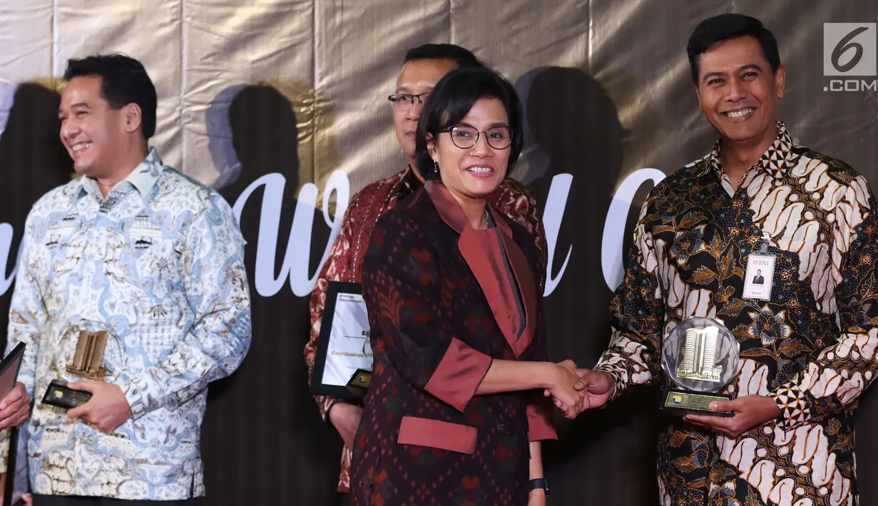Menteri Keuangan Sri Mulyani (dua kanan) memberikan penghargaan Wajib Pajak 2019 kepada Direktur Keuangan BNI Anggoro Eko Cahyo di Jakarta, Rabu (13/3). Sri Mulyani memberikan apresiasi dan penghargaan kepada 30 Wajib Pajak (WP). (Liputan6.com/JohanTallo)