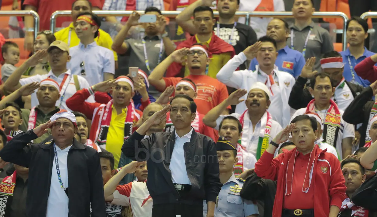 Presiden RI, Joko Widodo saat menyanyikan lagu Indonesia Raya pada laga semifinal AFF Cup 2016 antara Indonesia melawan Vietnam di Stadion Pakansari, Bogor, (03/12/2016). (Bola.com/Nicklas Hanoatubun)