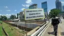 Warga melintas di depan pembangunan jalan inspeksi di Bantaran KBB kawasan Thamrin, Jakarta, Selasa (17/3/2015). Pembangunan jalan yang diproyeksikan untuk jalur alternatif bagi warga ini diperkirakan rampung pertengahan 2015. (Liputan6.com/Faizal Fanani)