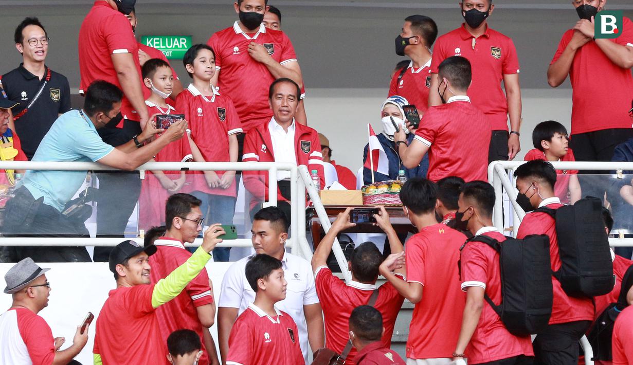 Presiden RI, Joko Widodo, menyempatkan diri melayani permintaan foto bersama suporter cilik di sela-sela rehat babak pertama pertandingan Timnas Indonesia melawan Thailand pada laga Piala AFF 2022 di Stadion Utama Gelora Bung Karno (SUGBK), Jakarta, Kamis (29/12/2022). (Bola.com/M Iqbal Ichsan)