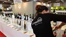 Pengunjung membuka botol wine organik dalam acara Millesime Bio 2018 di Kota Montpellier, Prancis, Senin (29/1). (AFP PHOTO/PASCAL GUYOT)