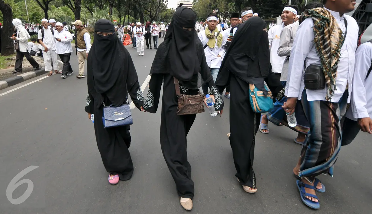 Sejumlah demonstran perempuan mengikuti aksi damai sambil berjalan kaki di Jalan Medan Merdeka Selatan, Jakarta, Jumat (4/11). Ratusan ribu massa aksi damai melakukan aksi menuntut penegakan hukum kasus dugaan penistaan agama. (Liputan6.com/Yoppy Renato)