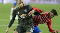 Striker Manchester United, Mason Greenwood (depan) berusaha melepaskan diri dari penjagaan pemain Granada dalam lanjutan Liga Europa 2020/2021, Jumat (9/4/2021) dini hari WIB. (CRISTINA QUICLER / AFP)