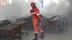 Petugas melakukan pengasapan (fogging) di sebuah sekolah di kawasan Kebon Baru, Tebet, Jakarta, Kamis (28/2). Pengasapan dilakukan terkait adanya warga di kawasan tersebut yang terkena penyakit demam berdarah. (Liputan6.com/Immanuel Antonius)