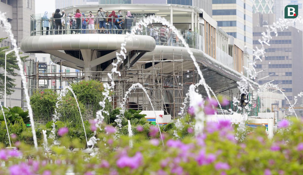 Sejumlah warga asyik berfoto di anjungan Halte Transjakarta Bundaran HI, Jakarta, Minggu (06/11/2022). (Bola.com/M Iqbal Ichsan)