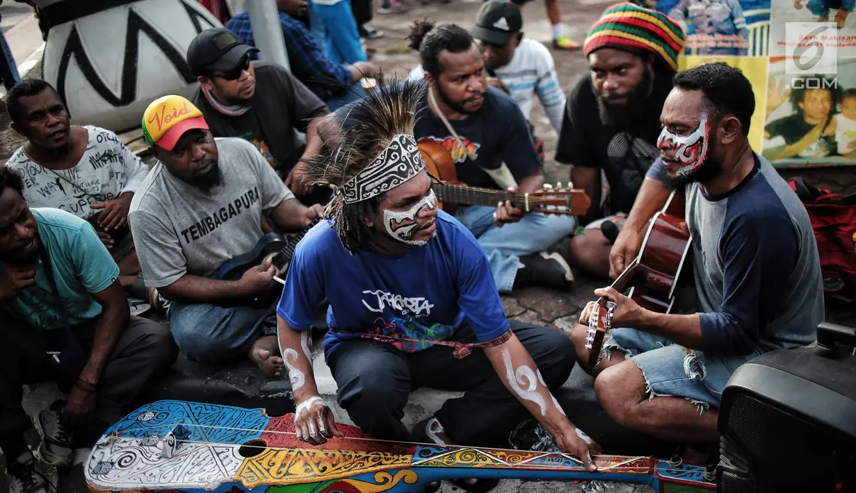 Eks pekerja PT Freeport Indonesia bermain musik saat menggelar aksi selama Car Free Day di kawasan Bunderan HI, Jakarta, Minggu (30/12). Sebanyak 3.274 pekerja Freeport diberhentikan secara sepihak oleh manajemen. (Liputan6.com/Faizal Fanani)