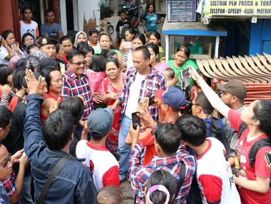 Warga Jelambar Timur mengambil gambar Cawagub DKI Jakarta, Djarot Saiful Hidayat saat blusukan ke Jelambar, Jakarta, Jumat (6/1). Dalam blusukannya Djarot meminta kepada warga agar tidak termakan oleh isu yang menimbulkan keresahan. (Liputan6.com)