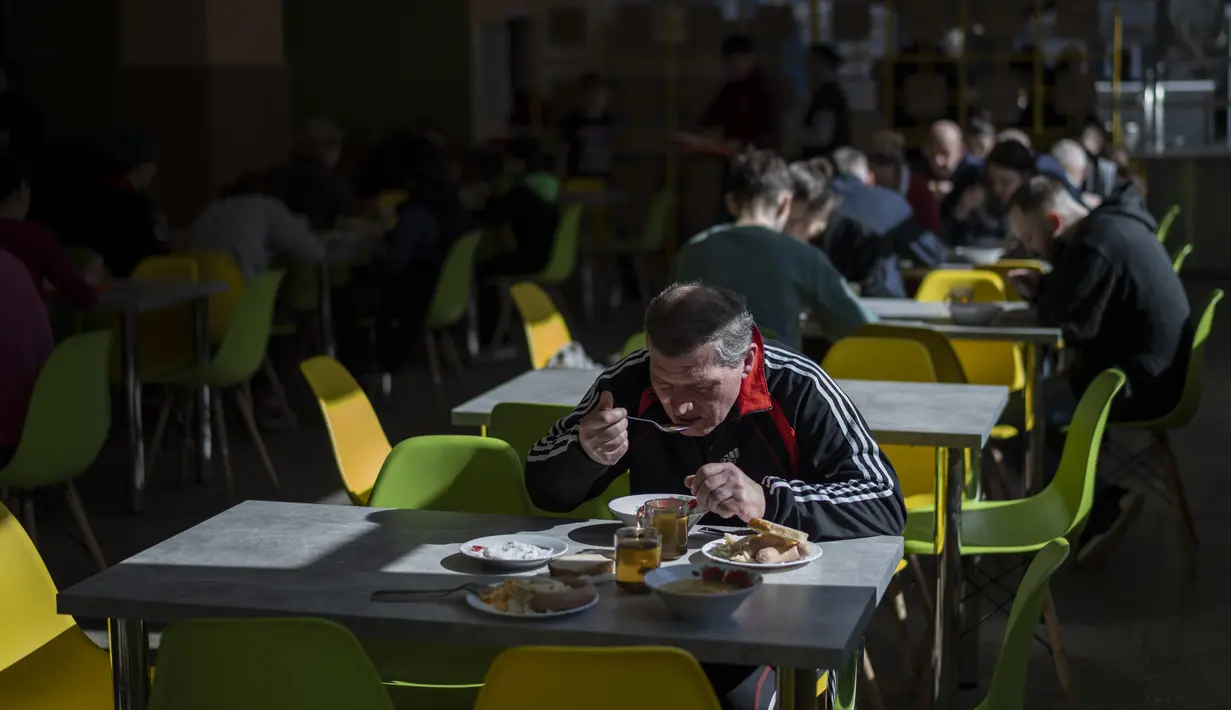 Para pengungsi internal makan siang di kantin sekolah di Lviv, Ukraina barat, Senin, 14 Maret 2022. Pada 24 Februari 2022, Rusia melancarkan invasi berskala besar ke Ukraina, salah satu negara tetangganya di sebelah barat daya. (AP Photo/Bernat Armangue)