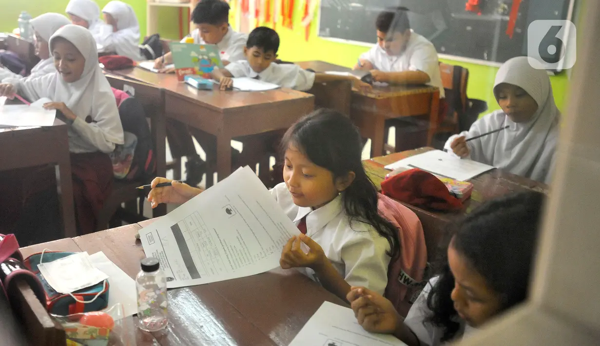 Siswa mengikuti ujian penilaian akhir semester (PAS) yang dihadiri guru pengawas di SDN Pondok Cina 1 Depok, Jawa Barat, Senin (5/12/2022). Guru SDN Pondokcina 1 Depok kembali hadir di sekolah itu pada hari ini. (merdeka.com/Arie Basuki)