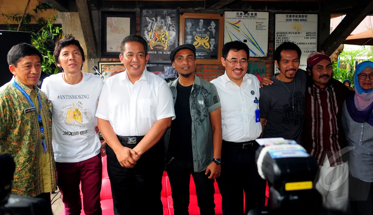 Personel grup band Slank dan manager Slank, Bunda Iffet (kanan) berpose bersama petugas BNN usai melakukan pertemuan di Markas Slank, Gang Potlot, Jakarta, Selasa (17/3/2015). (Liputan6.com/Yoppy Renato)