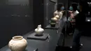 Pengunjung mengamati benda yang dipajang dalam pameran keramik di Zhengzhou, Provinsi Henan, China, 25 Agustus 2020. Pameran keramik tersebut dimulai di Zhengzhou pada Selasa (25/8) dengan menampilkan 100 lebih benda dari zaman kuno yang ditemukan di sepanjang cekungan Sungai Kuning. (Xinhua/Li An)