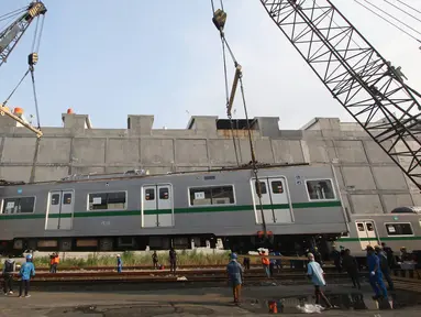 Petugas menurunkan gerbong KRL seri 6000 yang tiba di Pelabuhan Tanjung Priok, Jakarta, Jumat (29/7). Pada tahap pertama tahun ini, PT KAI Commuter Jabodetabek mendatangkan 30 dari 60 unit KRL Tokyo Metro Jepang. (Liputan6.com/Immanuel Antonius)