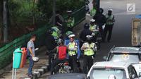 Petugas kepolisian memeriksa kelengkapan surat-surat pengendara bermotor saat Operasi Keselamatan Jaya 2018  di Jalan Letjen Suprapto, Jakarta, Senin (5/3). Dalam operasi hari pertama, Polda Metro menerjunkan 2.704 personel. (Liputan6.com/Arya Manggala)