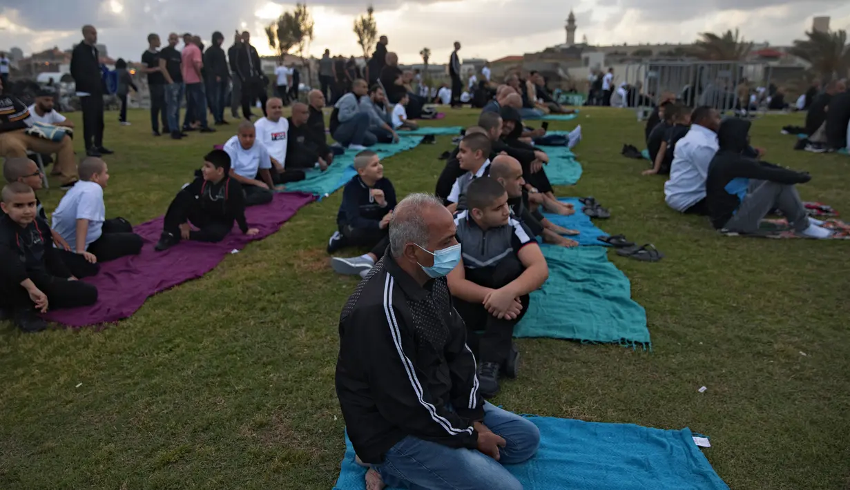 Umat muslim berkumpul untuk melaksanakan salat Idul Fitri yang menandai berakahirnya bulan suci Ramadan di sebuah taman di Jaffa, Israel, Minggu (24/5/2020). Jaffa merupakan kota campuran Yahudi-Arab. (AP Photo/Oded Balilty)