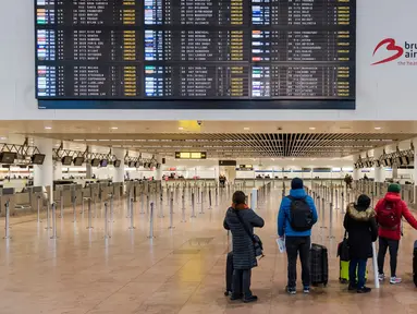Penumpang melihat layar informasi keberangkatan di Bandara Brussels, Zaventem, Belgia, Rabu (13/2). Menurut badan lalu lintas udara Skeyes, wilayah udara Belgia ditutup selama 24 jam. (AP Photo/Geert Vanden Wijngaert)
