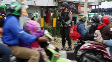 Polisi bersenjata laras panjang berjaga di jalur pantura Jalan Jenderal Ahmad Yani, Bypass, Kota Cirebon, Kamis (22/6). Pasukan bersenjata lengkap diterjunkan untuk mengantisipasi gangguan keamanan selama arus mudik Lebaran.  (Liputan6.com/Johan Tallo)