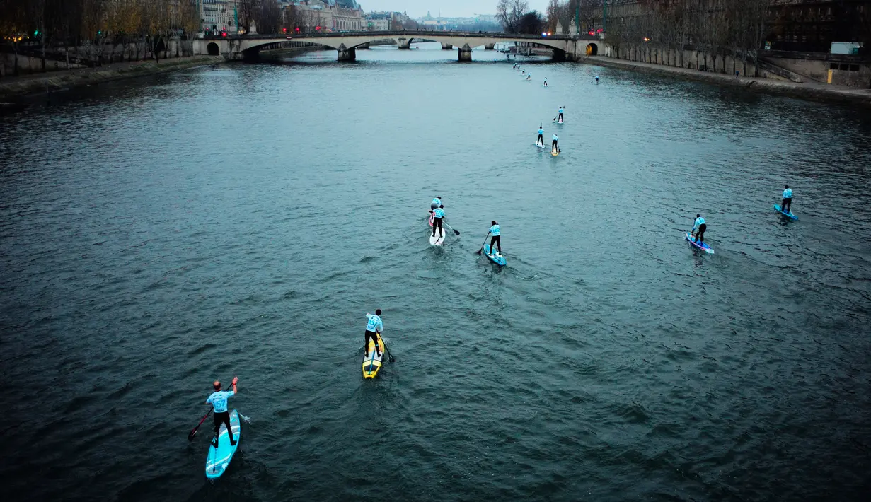 Peserta mendayung melewati aliran sunga- sungai selama perlombaan dayung dan perahu di Sungai Seine di Paris, Perancis, Minggu, (2/12). Acara ini diikuti oleh ribuan peserta dari berbagai kota di Paris. (AFP)