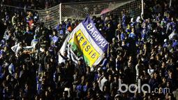 Aksi Bobotoh mengibarkan bendera dengan logo klub Persib Bandung pada Launching Jersey dan tim  di Stadion Siliwangi, Bandung, Minggu (2/4/2017). Jersey baru akan digunakan untuk mengarungi Liga 1 Indonesia. (Bola.com/Nicklas Hanoatubun)