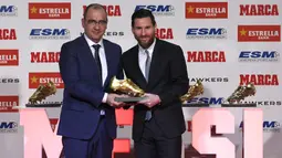 Striker Barcelona, Lionel Messi, bersama direktur Marca berpose saat menerima trofi Sepatu Emas Eropa di Antiga Fabrica Estrella Damm, Selasa, (18/12/2018). Messi berhak atas penghargaan itu berkat koleksi 34 gol dari 36 pertandingan. (AFP/Lluis Gene)