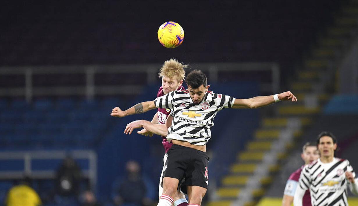 Gelandang Manchester United, Bruno Fernandes, berebut bola dengan pemain Burnley, Ben Mee, pada laga Liga Inggris di Stadion Turf Moor, Rabu (13/1/2021). Setan Merah menang dengan skor 1-0. (Peter Powell/Pool via AP)