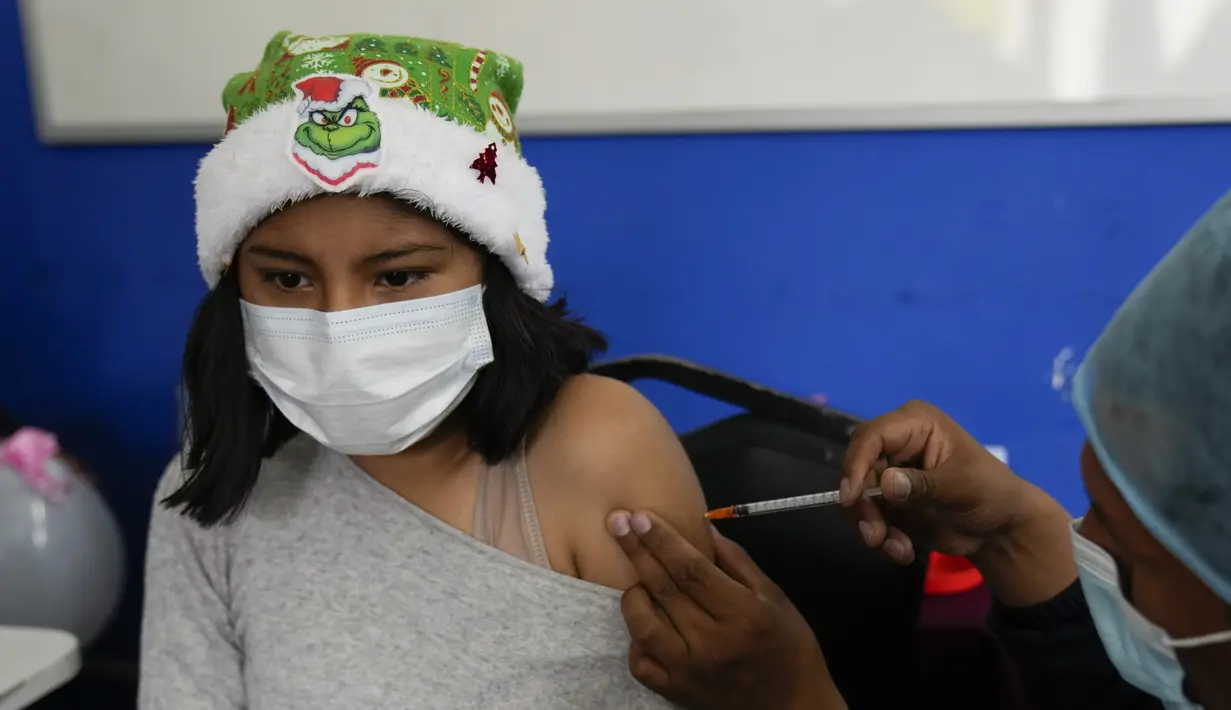 Seorang anak menerima dosis vaksin covid-19 Sinopharm di La Paz, Bolivia, Kamis (9/12/2021). Presiden Bolivia Luis Arce mengizinkan vaksinasi anak berusia antara 5 hingga 11 tahun untuk menekan laju peningkatan infeksi COVID-19 di negara itu. (AP Photo/Juan Karita)