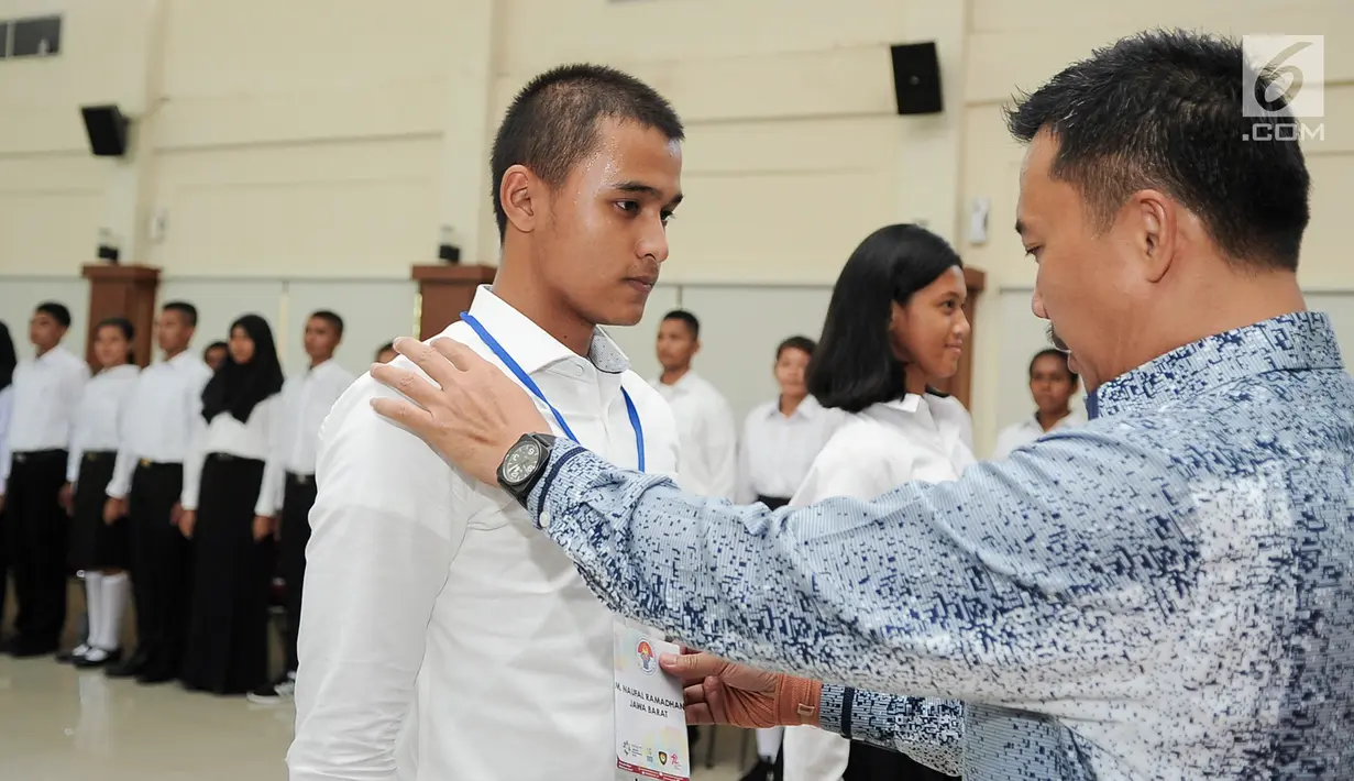 Menpora Imam Nahrawi mengalungkan tanda pengenal saat pembukaan Pusdiklat Paskibraka Nasional 2017 di PP-PON Cibubur, Jakarta, Rabu (26/7). Sebanyak 68 putra dan putri terbaik dari 34 Provinsi di Indonesia menjalani Pusdiklat. (Liputan6.com/Yoppy Renato)