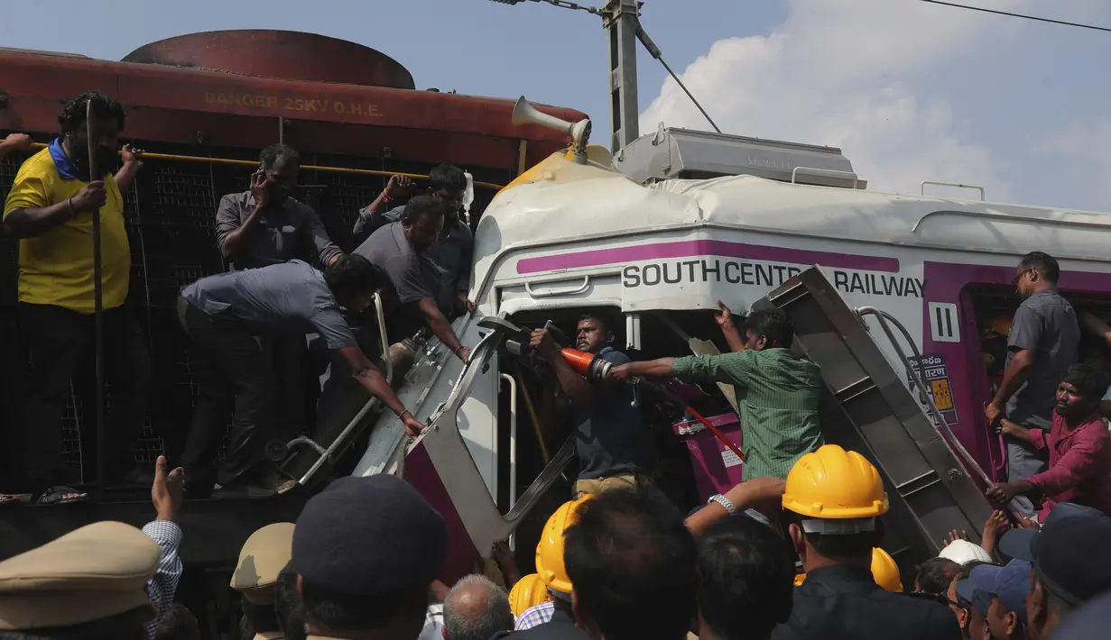 Petugas berusaha menyelematkan seorang pekerja di kabin kereta api surburban setelah bertabrakan dengan kereta ekspres antarkota di Stasiun Kereta Api Kachiguda di Hyderabad, India (11/9/2019). Sekitar 12 orang terluka akibat kecelakaan tersebut. (AP Photo/Mahesh Kumar A.)