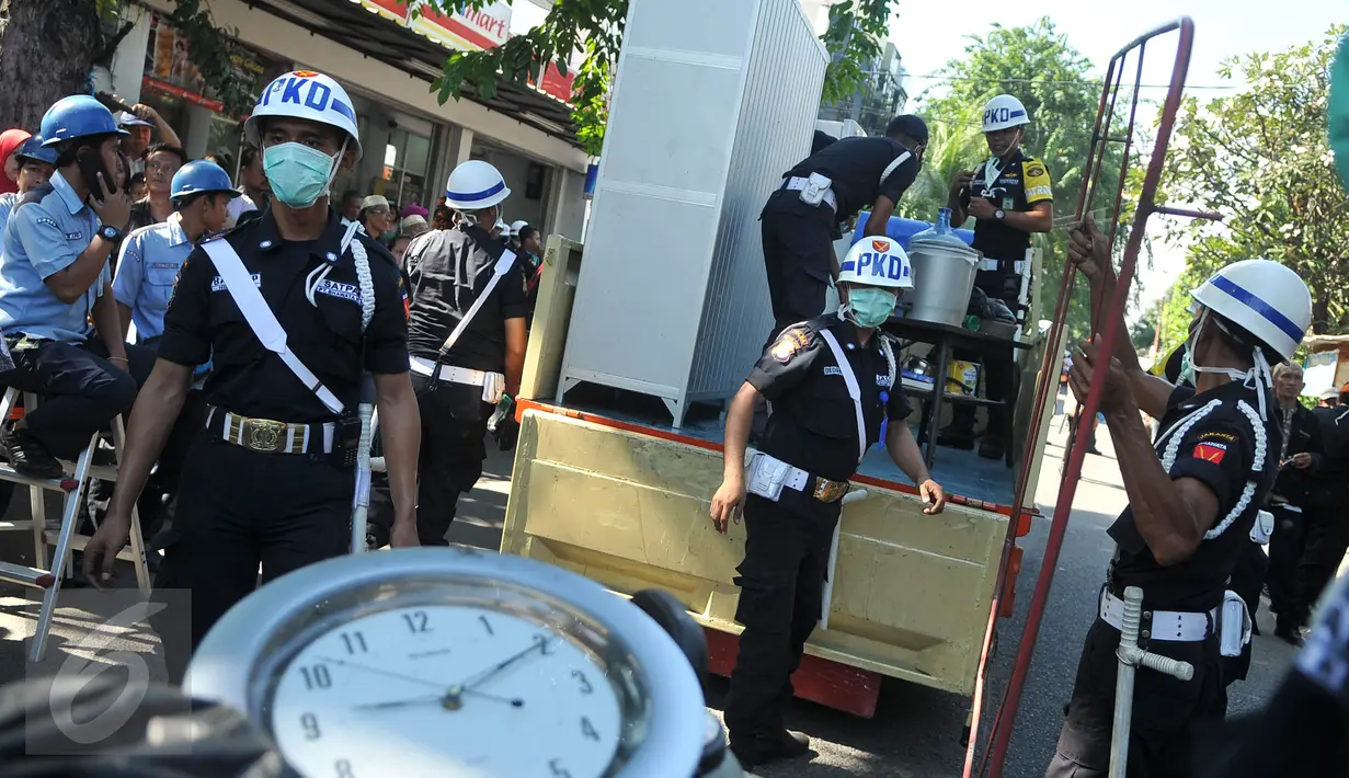 Petugas mengeluarkan barang milik warga saat eksekusi pengosongan rumah dinas pensiunan PT KAI di Jalan Bungur Besar, Kompleks PJKA, Senen, Jakarta, Kamis (14/4). Tanah seluas 60.930 m2 itu akan digunakan untuk parkir kereta. (Liputan6.com/Gempur M Surya)