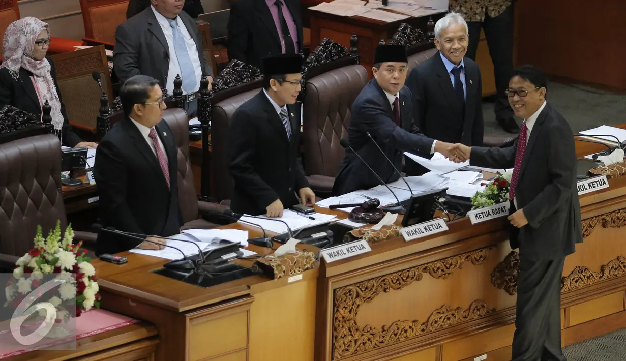 Ketua Komisi XI Ahmadi Noor Supid menyerahkan laporan hasil pembahasan RUU Pengampunan Pajak kepada Ketua DPR Ade Komarudin (kedua kanan), Jakarta, Selasa (28/6). Hanya 261 anggota DPR yang hadir dari total 558 anggota. (Liputan6.com/Johan Tallo)