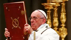 Paus Fransiskus memegang kitab Injil saat memimpin misa Natal di Basilika Santo Petrus, Vatikan, (24/12). Pada misa tersebut, Paus mengatakan bahwa Natal sudah "disandera" oleh materialisme. (REUTERS/Tony Gentile)