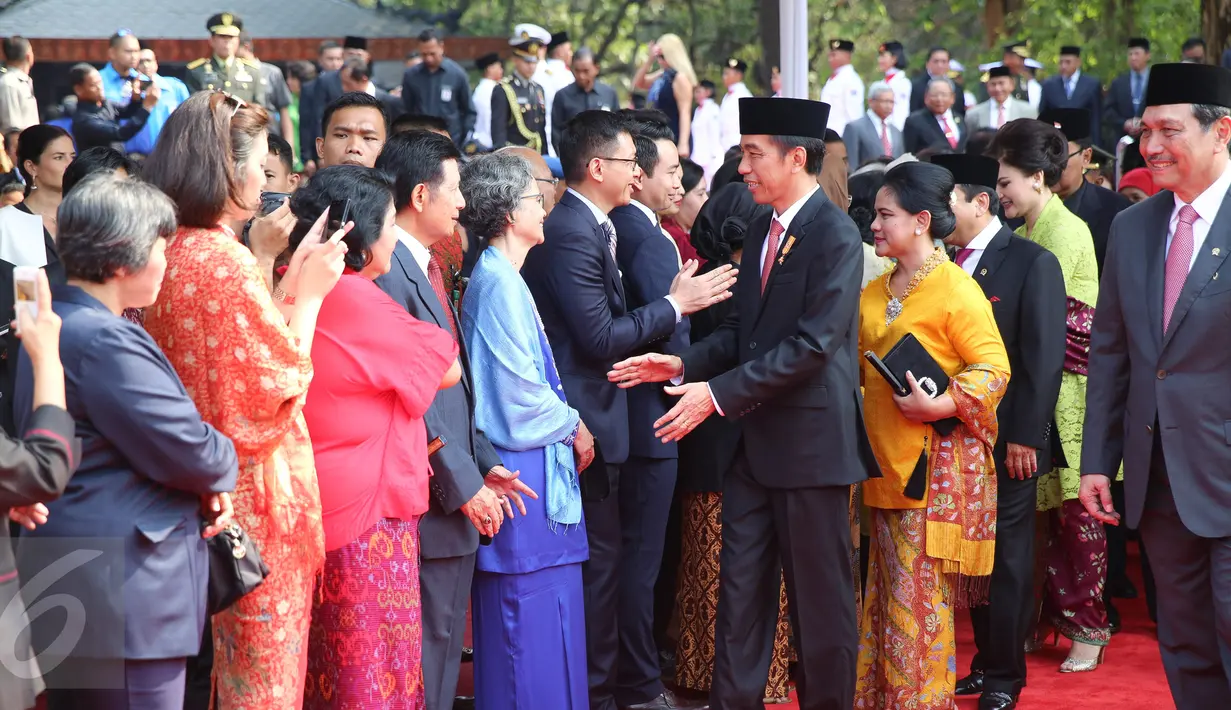 Presiden Jokowi menyalami putra-putra anak pahlawan revolusi yang hadir dalam upacara Hari Kesaktian Pancasila seusai memimpin upacara tersebut di Monumen Pancasila Sakti, Jakarta, Kamis (1/10).‎ (Liputan6.com/Faizal Fanani)