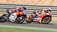 Momen saat pembalap Repsol Honda, Marc Marquez beradu kecepatan dengan pembalap Ducati, Andrea Dovizioso pada MotoGP Aragon 2018. (JOSE JORDAN / AFP)
